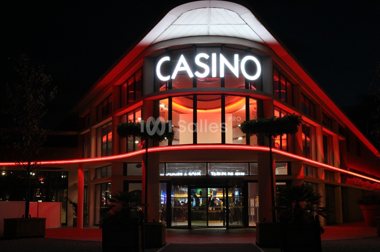 Façade d'un casino illuminé la nuit avec des néons rouges et une enseigne lumineuse ’CASINO’.