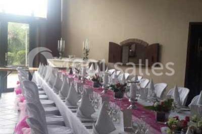 Miniature Location salle Belœil (Hainaut) - La Grange Aux Artistes #6 Jardin ensoleillé avec des palmiers au premier plan, pelouse verte et tables hautes recouvertes de nappes noires en arrière…