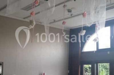 Miniature Location salle Belœil (Hainaut) - La Grange Aux Artistes #9 Jardin ensoleillé avec des palmiers au premier plan, pelouse verte et tables hautes recouvertes de nappes noires en arrière…