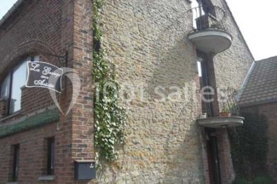 Miniature Location salle Belœil (Hainaut) - La Grange Aux Artistes #22 Jardin ensoleillé avec des palmiers au premier plan, pelouse verte et tables hautes recouvertes de nappes noires en arrière…