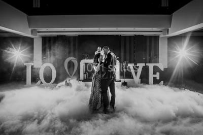 Miniature Location salle Gémenos (Bouches-du-Rhône) - Le Riviera #17 Un couple danse au milieu d'une piste entourée de fumée, avec des lettres géantes formant ’LOVE’ en arrière-plan.