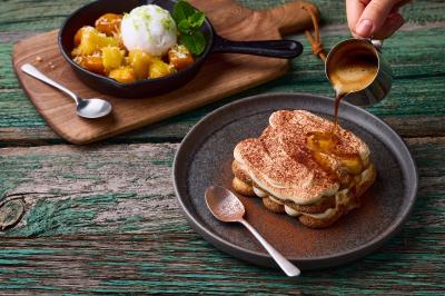 Miniature Location salle Boulogne-Billancourt (Hauts-de-Seine) - Hippopotamus Boulogne #13 Plat de viande rouge tranchée avec sauce au poivre, accompagné de frites, servi dans un plat ovale sur une table en bois.