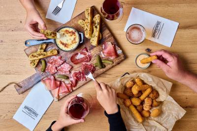 Miniature Location salle Boulogne-Billancourt (Hauts-de-Seine) - Hippopotamus Boulogne #24 Plat de viande rouge tranchée avec sauce au poivre, accompagné de frites, servi dans un plat ovale sur une table en bois.