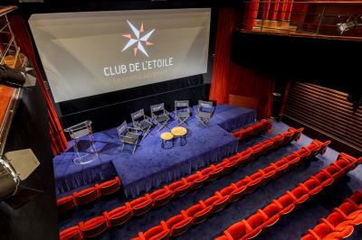 Façade du cinéma ’Club de l'Étoile’ avec une entrée vitrée et des voitures stationnées devant.
