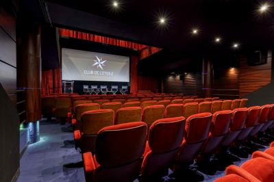 Façade du cinéma ’Club de l'Étoile’ avec une entrée vitrée et des voitures stationnées devant.