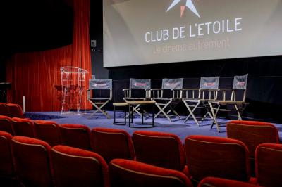 Façade du cinéma ’Club de l'Étoile’ avec une entrée vitrée et des voitures stationnées devant.