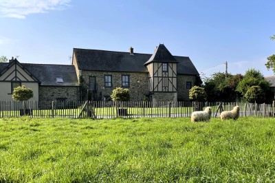 Miniature Bâtisse Manoir Chambre mansardée avec lit double, poutres apparentes, éclairage chaleureux et fenêtre de toit.
