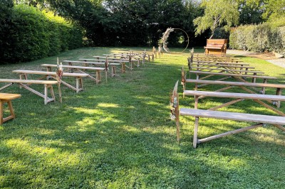 Miniature Cérémonie Laïque jardin Chambre mansardée avec lit double, poutres apparentes, éclairage chaleureux et fenêtre de toit.