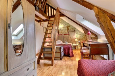 Miniature Chambre coq Chambre mansardée avec lit double, poutres apparentes, éclairage chaleureux et fenêtre de toit.