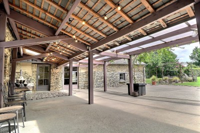 Miniature Préau pour cocktails Chambre mansardée avec lit double, poutres apparentes, éclairage chaleureux et fenêtre de toit.