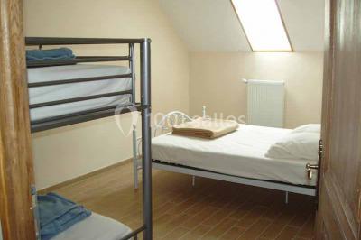 Miniature Location salle Menus (Orne) - Gîte de La Bretillière #8 Chemin de campagne bordé de poteaux électriques et clôtures, traversant un paysage rural sous un ciel sombre.