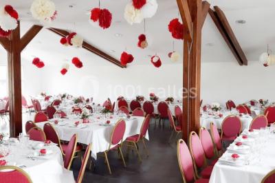 Miniature Location salle Saint-Pôtan (Côtes-d'Armor) - La Métairie de la Barre #17 Table ronde décorée pour un événement, avec nappes beige, chaises blanches ornées de tissu orange et centre de table floral.