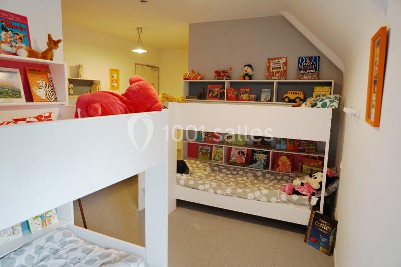 Location salle Saint-Pôtan (Côtes-d'Armor) - La Métairie de la Barre #21 Chambre d'enfants avec lits superposés, étagères remplies de livres et jouets colorés.