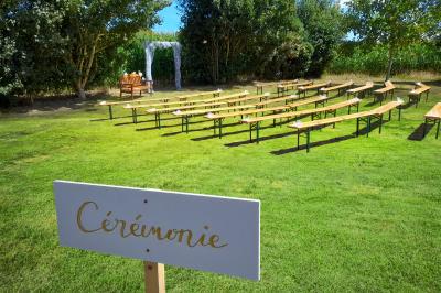 Miniature Location salle Saint-Pôtan (Côtes-d'Armor) - La Métairie de la Barre #2 Table ronde décorée pour un événement, avec nappes beige, chaises blanches ornées de tissu orange et centre de table floral.