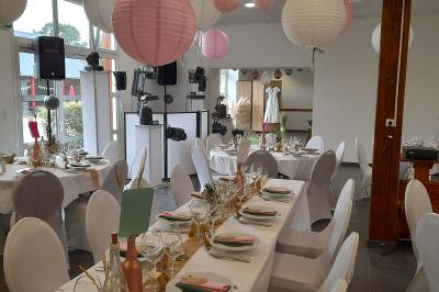 Miniature Location salle Saint-Pôtan (Côtes-d'Armor) - La Métairie de la Barre #15 Table ronde décorée pour un événement, avec nappes beige, chaises blanches ornées de tissu orange et centre de table floral.