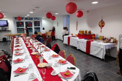 Miniature Location salle Saint-Pôtan (Côtes-d'Armor) - La Métairie de la Barre #22 Table ronde décorée pour un événement, avec nappes beige, chaises blanches ornées de tissu orange et centre de table floral.