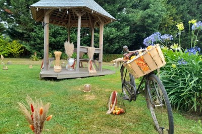 Miniature Location salle Saint-Pôtan (Côtes-d'Armor) - La Métairie de la Barre #27 Table ronde décorée pour un événement, avec nappes beige, chaises blanches ornées de tissu orange et centre de table floral.