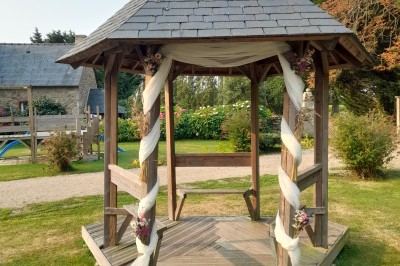 Miniature Location salle Saint-Pôtan (Côtes-d'Armor) - La Métairie de la Barre #31 Table ronde décorée pour un événement, avec nappes beige, chaises blanches ornées de tissu orange et centre de table floral.