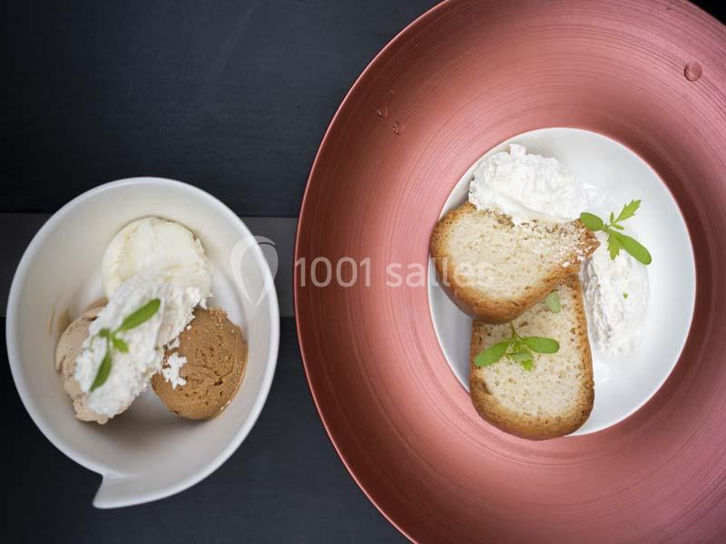 Deux assiettes contenant des desserts : une avec des boules de glace, l'autre avec des tranches de gâteau et de la crème.