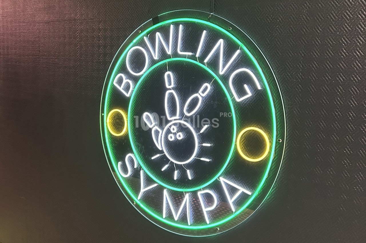 Enseigne lumineuse circulaire avec l'inscription ’Bowling Sympa’ et des quilles stylisées au centre.