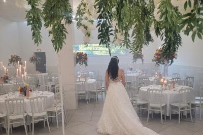 Table de réception élégamment dressée avec nappes blanches, serviettes décorées, verres et couverts alignés.