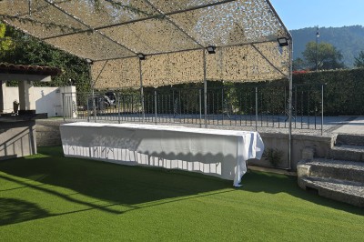 Table de réception élégamment dressée avec nappes blanches, serviettes décorées, verres et couverts alignés.