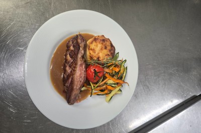 Table de réception élégamment dressée avec nappes blanches, serviettes décorées, verres et couverts alignés.