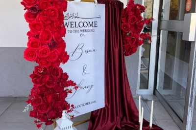 Table de réception élégamment dressée avec nappes blanches, serviettes décorées, verres et couverts alignés.