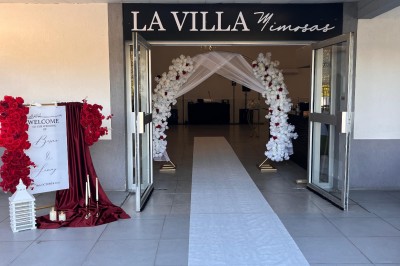 Table de réception élégamment dressée avec nappes blanches, serviettes décorées, verres et couverts alignés.