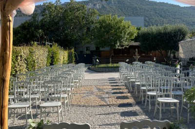 Table de réception élégamment dressée avec nappes blanches, serviettes décorées, verres et couverts alignés.