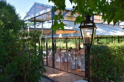 Salle de bain avec baignoire encastrée, lavabo sur meuble en marbre beige et fenêtre laissant entrer la lumière naturelle.