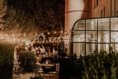Salle de bain avec baignoire encastrée, lavabo sur meuble en marbre beige et fenêtre laissant entrer la lumière naturelle.