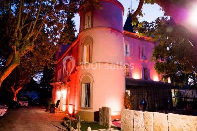 Salle de bain avec baignoire encastrée, lavabo sur meuble en marbre beige et fenêtre laissant entrer la lumière naturelle.