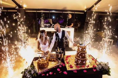 Salle de bain avec baignoire encastrée, lavabo sur meuble en marbre beige et fenêtre laissant entrer la lumière naturelle.