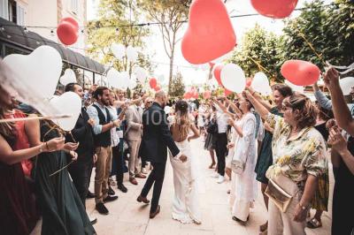 Salle de bain avec baignoire encastrée, lavabo sur meuble en marbre beige et fenêtre laissant entrer la lumière naturelle.