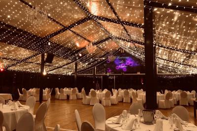 Salle de bain avec baignoire encastrée, lavabo sur meuble en marbre beige et fenêtre laissant entrer la lumière naturelle.