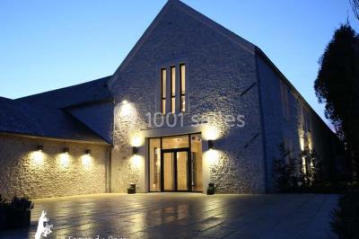 Jardin verdoyant avec pelouse bien entretenue, arbres et arbustes sous un ciel bleu dégagé.