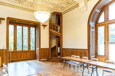 Miniature Location salle Chevreuse (Yvelines) - Château De Meridon #14 Tables élégamment dressées avec nappes vertes, chaises en bois et décor floral abondant dans une salle lumineuse.