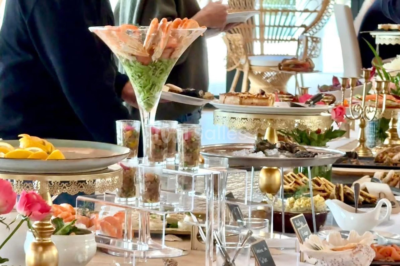 Buffet élégant avec verrines, fruits de mer, plats variés et décorations raffinées sur une table bien garnie.