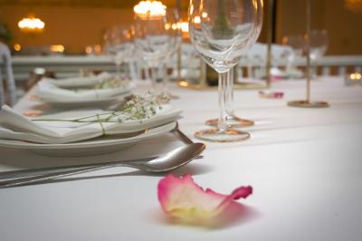 Salle tamisée avec des spectateurs assis à des tables éclairées par des bougies, face à une scène illuminée en rouge et bleu.