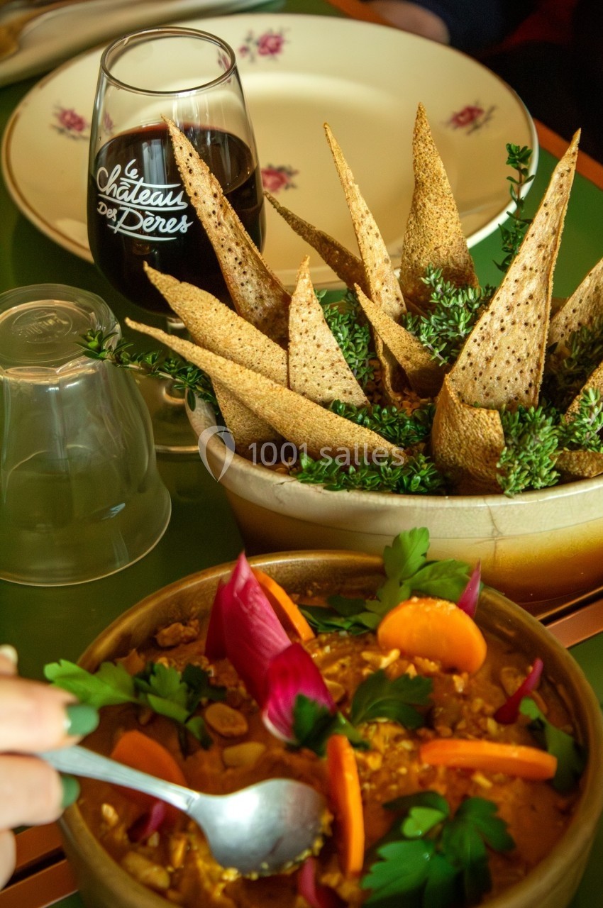 Plat de légumes colorés avec des herbes fraîches, accompagné de pain croustillant et d'un verre de vin rouge.