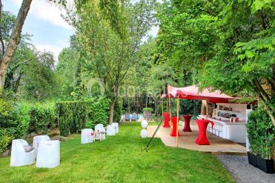 Miniature Location salle Bruxelles (Bruxelles-Capitale) - Villattitude #3 Escalier en bois sculpté avec rampe en métal, lustres suspendus et grandes fenêtres laissant entrer la lumière naturelle.
