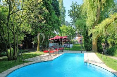 Miniature Location salle Bruxelles (Bruxelles-Capitale) - Villattitude #5 Escalier en bois sculpté avec rampe en métal, lustres suspendus et grandes fenêtres laissant entrer la lumière naturelle.