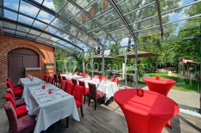 Miniature Location salle Bruxelles (Bruxelles-Capitale) - Villattitude #6 Escalier en bois sculpté avec rampe en métal, lustres suspendus et grandes fenêtres laissant entrer la lumière naturelle.