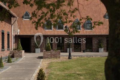 Tente blanche installée sur une pelouse, accueillant un événement avec des invités debout autour de tables hautes.