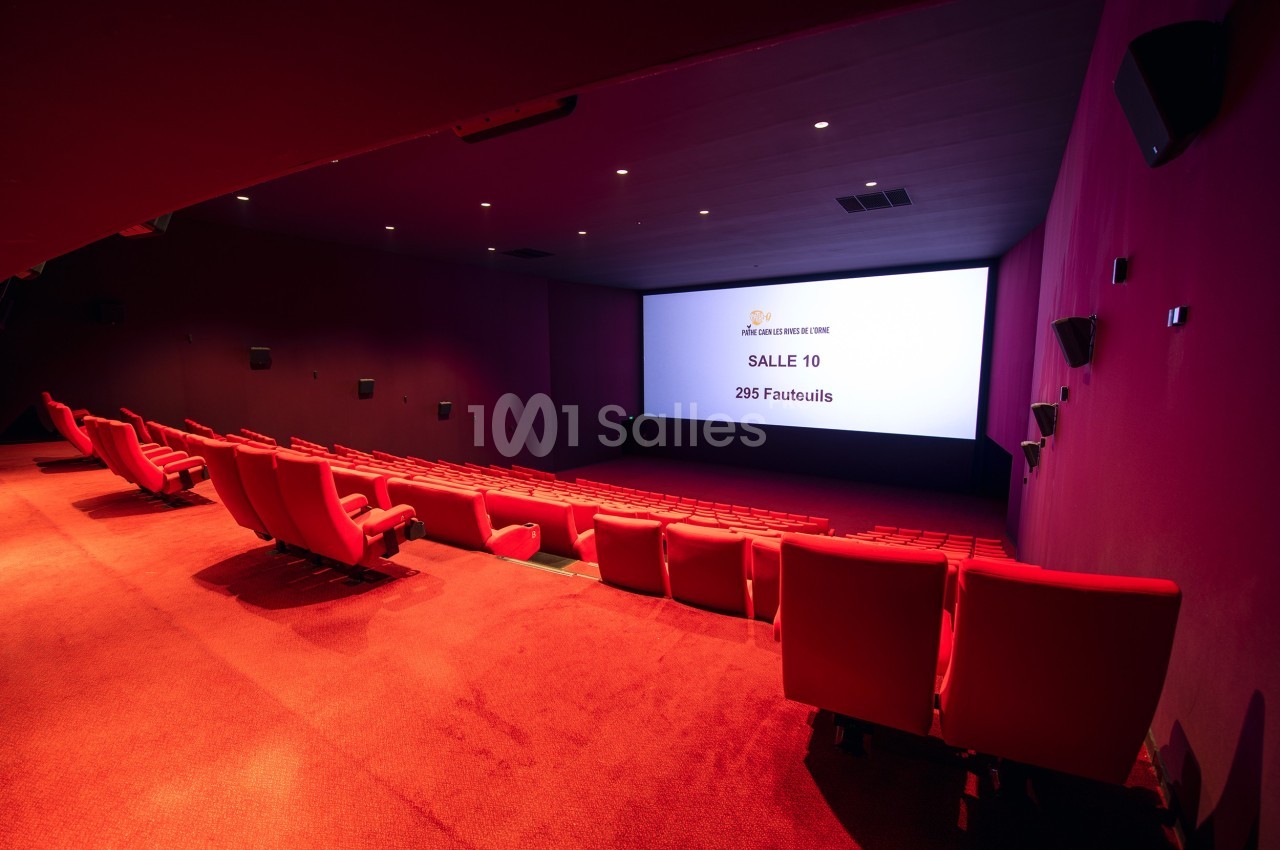 Salle de cinéma vide avec des rangées de fauteuils rouges et un écran affichant ’Salle 10 - 295 Fauteuils’.
