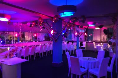 Miniature Location salle Marseille (Bouches-du-Rhône) - Le Greenwich #4 Salle de restaurant lumineuse avec tables dressées, chaises noires et blanches, et terrasse extérieure avec vue sur des…