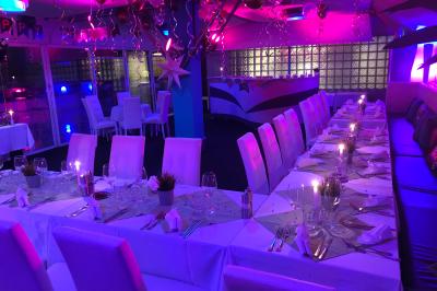 Miniature Location salle Marseille (Bouches-du-Rhône) - Le Greenwich #6 Salle de restaurant lumineuse avec tables dressées, chaises noires et blanches, et terrasse extérieure avec vue sur des…