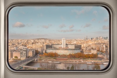 Miniature Location salle Paris 15 (Paris) - Hôtel Novotel Centre Paris Tour Eiffel #9 Vue de Paris à travers une fenêtre, montrant la Seine, un bâtiment moderne et l'horizon urbain avec des gratte-ciels.
