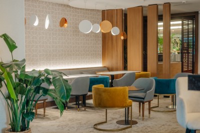 Miniature Bar QGrenelle Vue de Paris à travers une fenêtre, montrant la Seine, un bâtiment moderne et l'horizon urbain avec des gratte-ciels.
